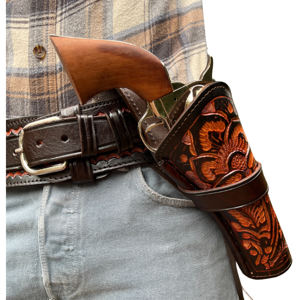 A leather holster with intricate tooling, designed to be worn across the body, fitted with a gun.