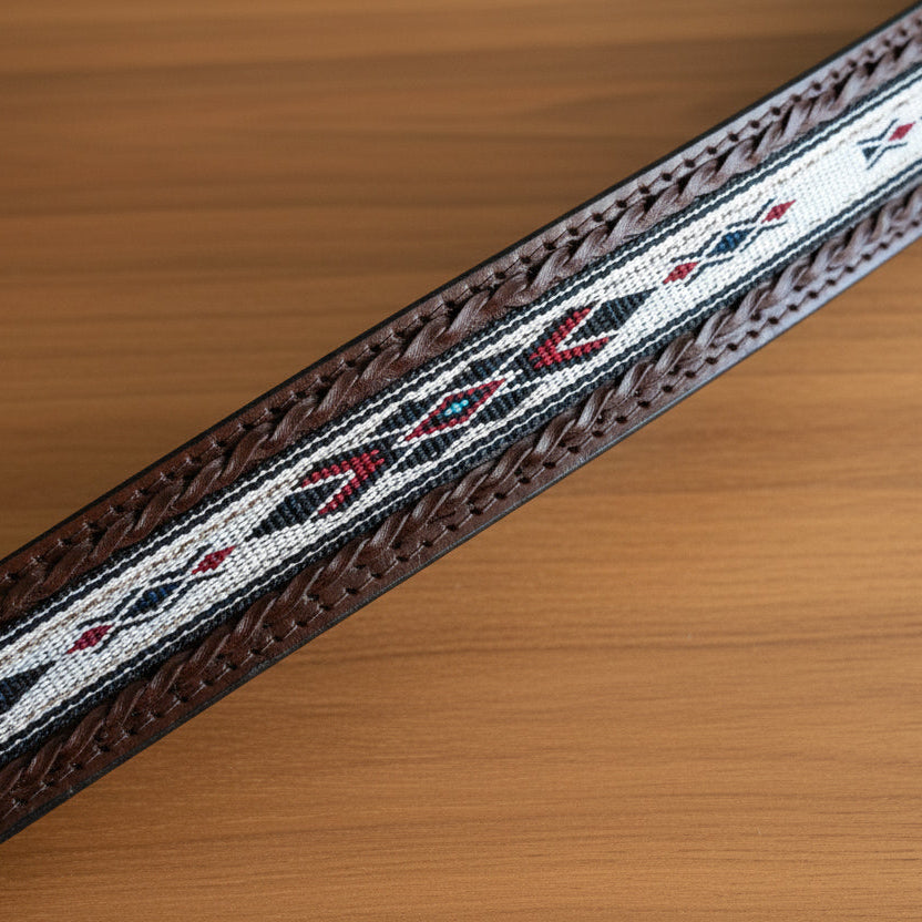 Close-up of a decorative belt with intricate patterns on a tiled floor background