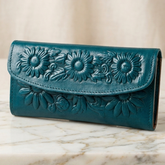 Teal wallet with floral embossing on a marble surface
