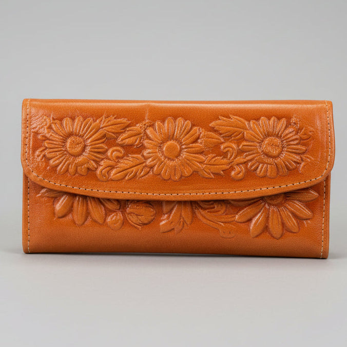 Brown leather wallet with floral embossing on a gray background
