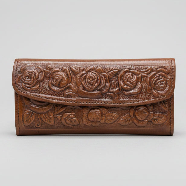 Brown leather wallet with floral patterns held by a hand against a blurred indoor background