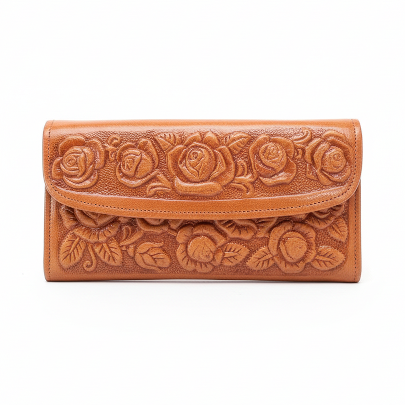 Brown leather wallet with floral embossing on a wooden surface