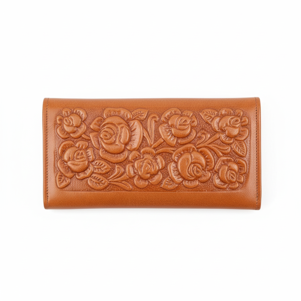 Brown leather wallet with floral embossing on a wooden surface