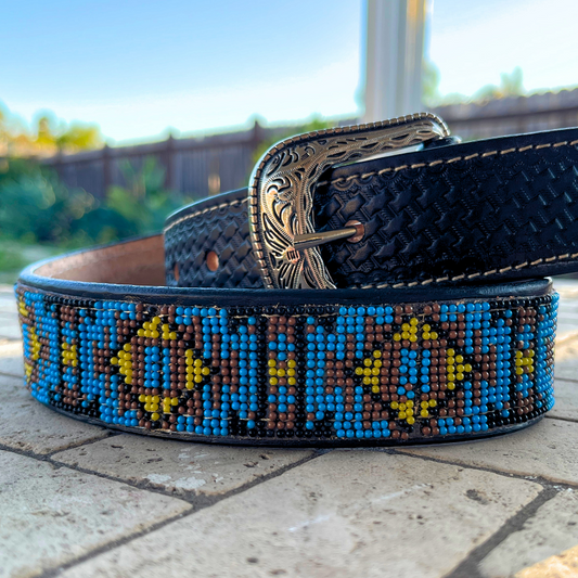 Beaded belt with decorative buckle on a stone surface